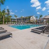 a pool with a building in the background and chairs