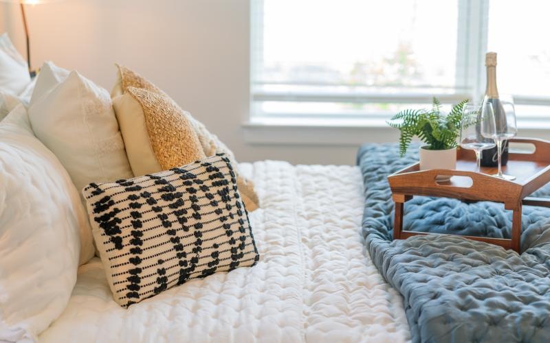 a bed with pillows and a mini table