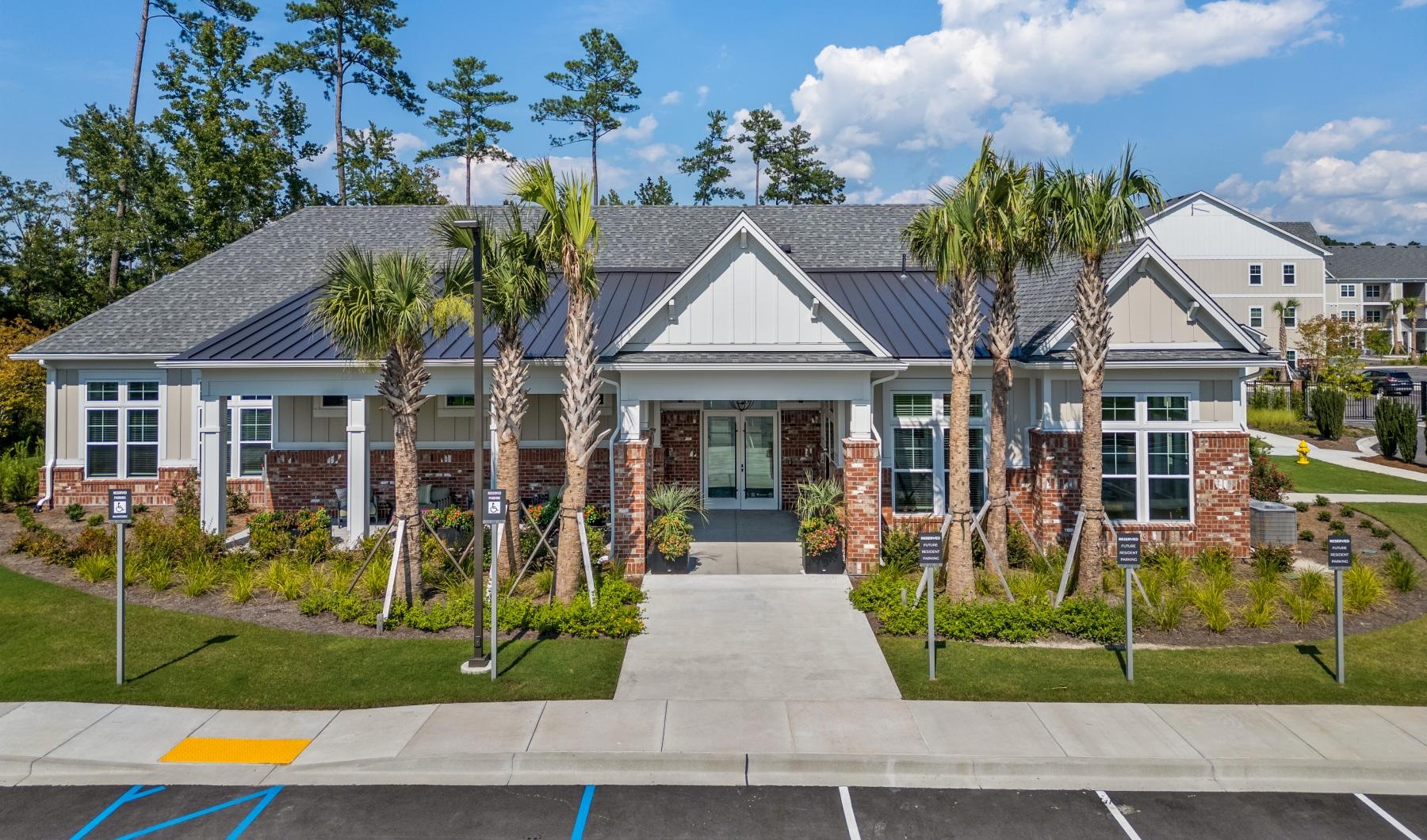 a leasing office with palm trees and a parking lot